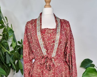 Peut inclure: Une longue robe en soie rouge à motif floral et bordure bleu et blanc. La robe a une ceinture à nouer à la taille.