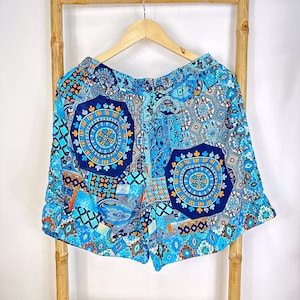 May include: Blue and orange patterned shorts with a geometric design. The shorts have a drawstring waist and a relaxed fit.