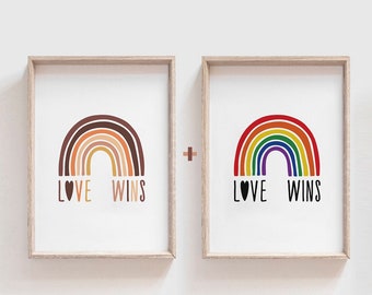 May include: Two framed prints with rainbow designs and the text "LOVE WINS". The first print features a rainbow with brown, orange, yellow, and beige stripes. The second print features a traditional rainbow with red, orange, yellow, green, blue, indigo, and violet stripes.