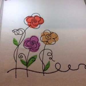 May include: Embroidered design of three stylized flowers with black stems and leaves. The flowers are orange, purple, and yellow.