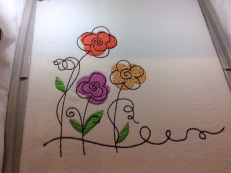May include: Embroidered design of three stylized flowers with black stems and leaves. The flowers are orange, purple, and yellow.