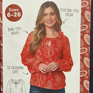 May include: A sewing pattern envelope for the Sun Chaser Blouse designed by Sophie Tarrant. The red blouse features a paisley print, a Peter Pan-style collar, tie-fastening cuffs, and a tie-neck detail. The pattern is available in sizes 6-28.