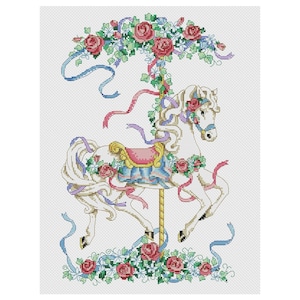 May include: White carousel horse with a pink and blue saddle, surrounded by a floral garland of pink roses and green leaves. The horse is decorated with blue and purple ribbons.