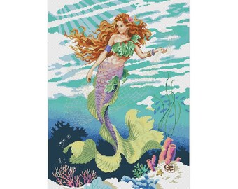 May include: A mermaid with long red hair and a purple tail swims in a turquoise ocean with green seaweed and coral. The mermaid is wearing a green seashell bra and a purple seashell skirt.