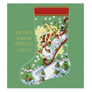 May include: A green Christmas stocking with a red cuff and a white snowy scene.  Snowmen are sliding down a hill with a green tree and red baubles.  The alphabet is printed in yellow on the stocking.
