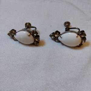 Pair of vintage screw on earrings. Egg shaped with three faux diamonds on the top and three faux diamonds on the bottom.
