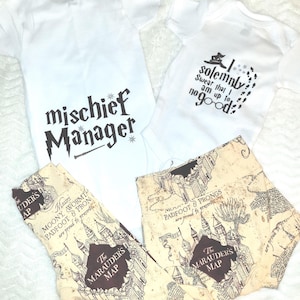 May include: White baby onesies with black text that reads "mischief Manager" and "I solemnly swear that I am up to no good." Also, a pair of beige leggings and shorts with a map design and the text "The Marauder's Map."
