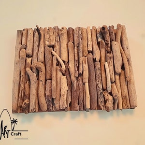 May include: A wall art piece made of driftwood arranged in a rectangular pattern. The driftwood is various shades of brown and beige.