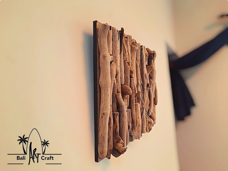 May include: A wall art piece made from driftwood, arranged in a vertical pattern. The wood is a natural brown color and has a rough texture. The piece is mounted on a black background.