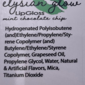 Puede incluir: Una etiqueta blanca con labios verdes y el texto "elysian glow Lip Gloss mint chocolate chip". Los ingredientes se enumeran a continuaci&oacute;n: Poliisobuteno hidrogenado (y) Copol&iacute;mero de etileno/propileno/estireno (y) Copol&iacute;mero de butileno/etileno/estireno, aceite de semilla de uva, propilenglicol, agua, sabores naturales y artificiales, mica, di&oacute;xido de titanio. El sitio web www.etsy.com/shop/ElysianGlowCo est&aacute; impreso en la parte inferior.