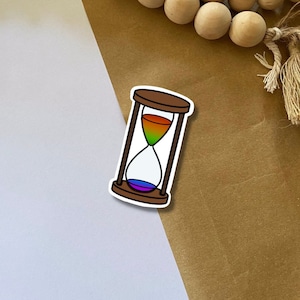時間 - 砂時計 - プライド - 平等 - LGBTQIA+ - カラフル - クィア - 安全な空間 - 電話 - ラップトップ - ノートブック - 人々 - 人生