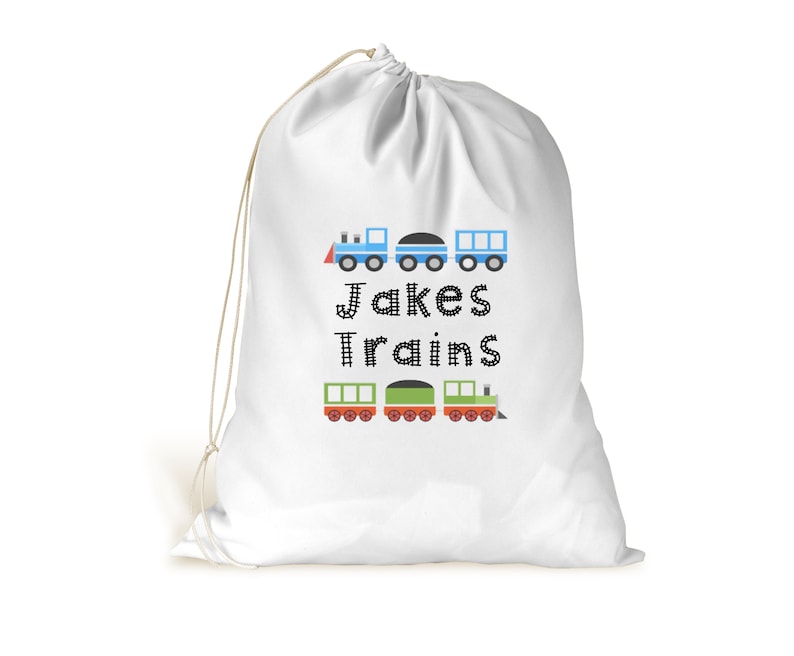 May include: White drawstring bag with a blue and green train design. The bag has the text "Jakes Trains" printed on it.
