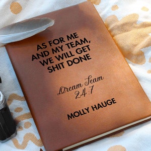 Puede incluir: Diario de cuero marrón con el texto "AS FOR ME AND MY TEAM, WE WILL GET SHIT DONE" y "Dream Seam 24:7" y "MOLLY HAUGE" en relieve en la portada.