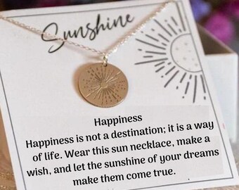 May include: A silver necklace with a gold sun pendant. The card reads "Sunshine Happiness is not a destination; it is a way of life. Wear this sun necklace, make a wish, and let the sunshine of your dreams make them come true."