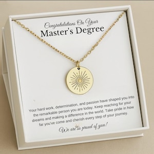 Puede incluir: Un collar de oro con un colgante redondo que presenta un diseño de rayos de sol viene en una caja blanca con un mensaje de felicitación por un Máster. El mensaje dice: "Felicidades por tu Máster. Tu trabajo duro, determinación y pasión te han convertido en la persona excepcional que eres hoy. Sigue alcanzando tus sueños y marcando la diferencia en el mundo. Siéntete orgulloso de todo lo que has logrado y aprecia cada paso de tu viaje. ¡Estamos muy orgullosos de ti!"