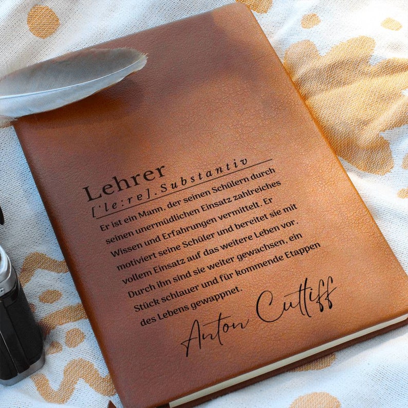 May include: A brown leather journal with the word "Lehrer" defined as a noun in German. The text reads, "Er ist ein Mann, der seinen Sch&uuml;lern durch seinen unerm&uuml;dlichen Einsatz zahlreiches Wissen und Erfahrungen vermittelt. Er motiviert seine Sch&uuml;ler und bereitet sie mit vollem Einsatz auf das weitere Leben vor. Durch ihn sind sie weiter gewachsen, ein St&uuml;ck schlauer und f&uuml;r kommende Etappen des Lebens gewappnet." The journal is signed "Anton Cultiff".