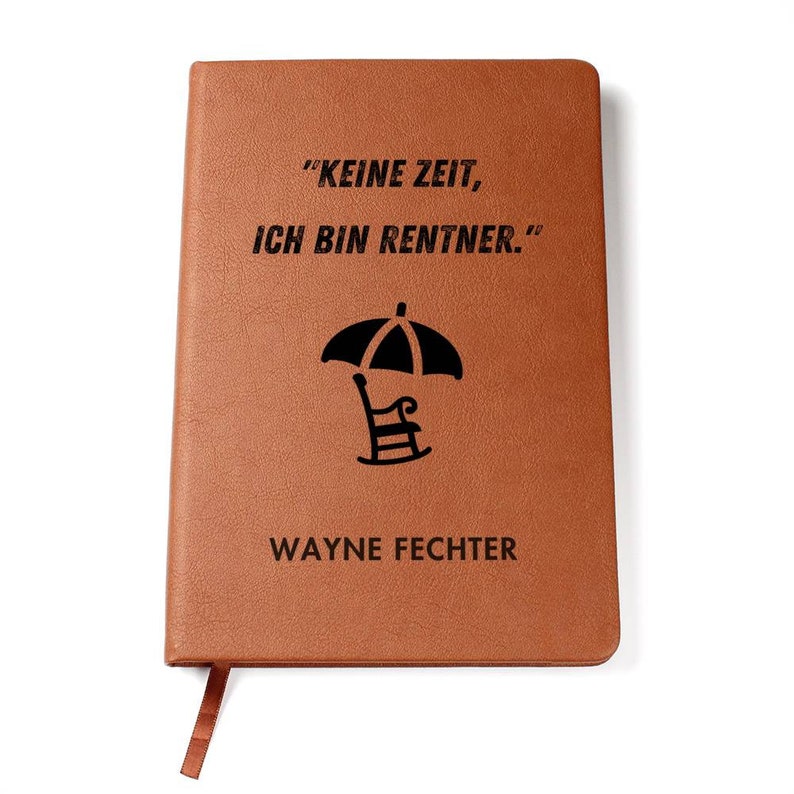 May include: A brown leather journal with the text "KEINE ZEIT, ICH BIN RENTNER." and a black silhouette of a beach chair under an umbrella. The name "WAYNE FECHTER" is printed below the image.