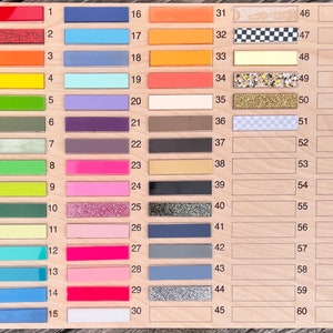 Pu&ograve; includere: Un pannello di legno con 60 campioni di colore numerati. I campioni sono disposti in sei colonne di dieci campioni ciascuna. I colori includono rosso, arancione, giallo, verde, blu, viola, rosa, marrone, nero, bianco e grigio.