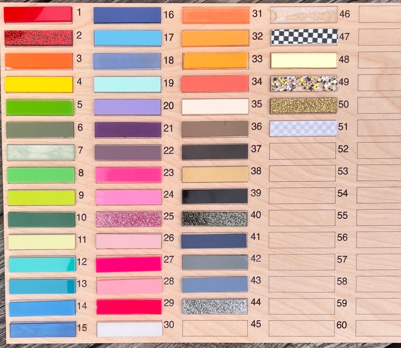 Pu&ograve; includere: Un pannello di legno con 60 campioni di colore numerati. I campioni sono disposti in sei colonne di dieci campioni ciascuna. I colori includono rosso, arancione, giallo, verde, blu, viola, rosa, marrone, nero, bianco e grigio.