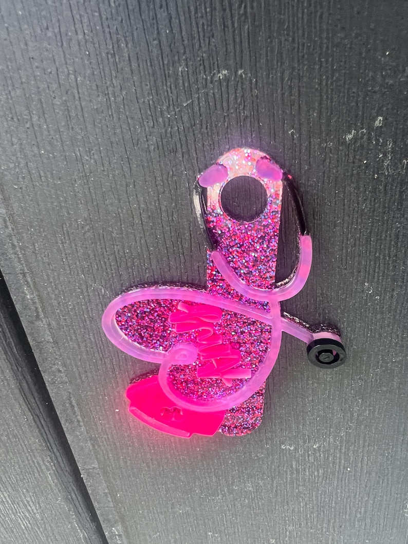 Pu&ograve; includere: Portachiavi stetoscopio con glitter rosa a forma di cuore con la scritta "Nurse" all'interno.