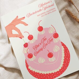 May include: A pink and red bachelorette party invitation with a cherry on top of a cake. The text reads "Madison's Bachelorette Weekend, San Diego, California, July 25-28th, 20XX, She's The Cherry On Top."