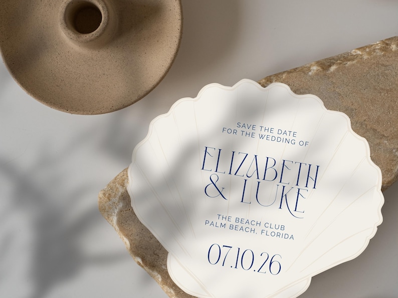 May include: Save the date for the wedding of Elizabeth & Luke at The Beach Club, Palm Beach, Florida on 07.10.26. The invitation is shaped like a seashell.