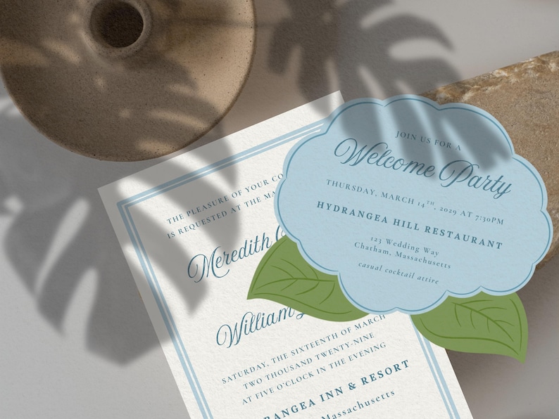 May include: Wedding invitation suite featuring a welcome party invitation in a cloud shape with green leaf accents. The invitation is light blue with elegant script. A second invitation with blue border is also visible.