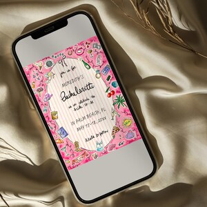 K&ouml;nnte beinhalten: Ein Smartphone zeigt eine rosa Aquarell-Einladung f&uuml;r Merediths Junggesellinnenabschied. Die Einladung enth&auml;lt dekorative Illustrationen von Flamingos, Champagner und anderen Party-Symbolen. Der Text lautet "In Palm Beach, FL, May 15-18, 20xx."