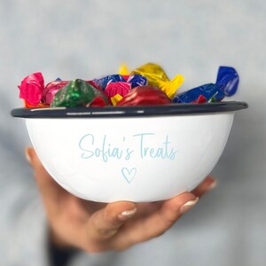 May include: White enamel bowl with a navy blue rim filled with colourful wrapped sweets. The bowl has the text "Sofia's Treats" in light blue script with a heart symbol below.
