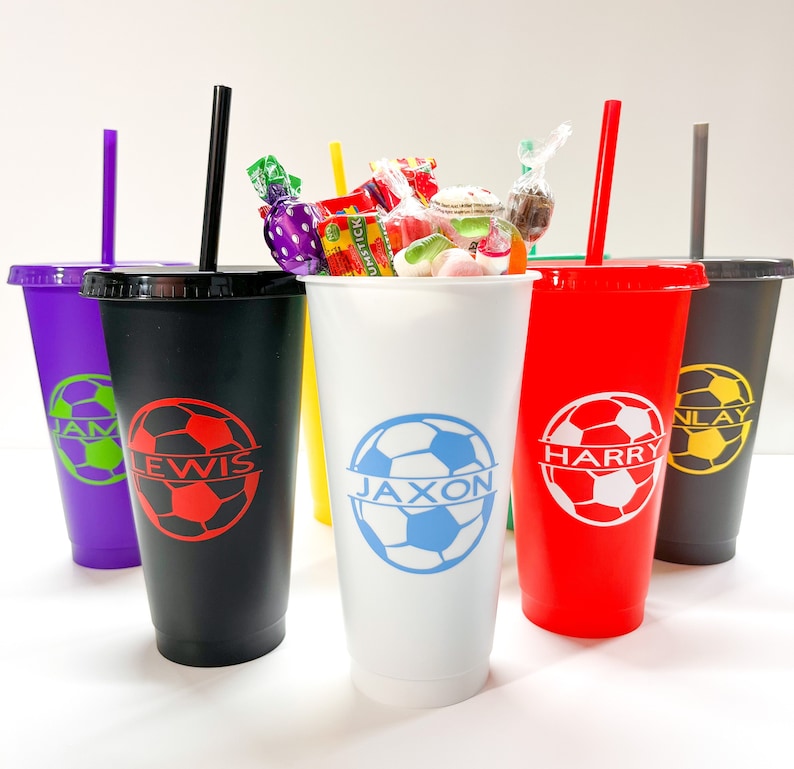 May include: Six personalized cups with soccer ball designs and names "Jaxon", "Harry", "Lewis", "Jam", and "Nlay". The cups are white, black, red, purple, and yellow.
