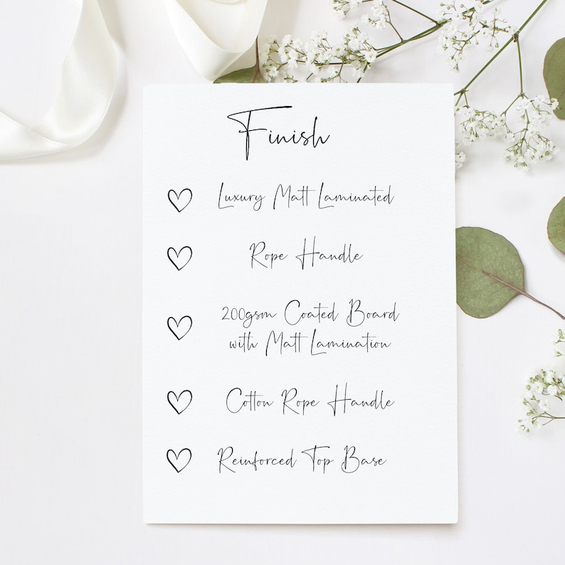 May include: A white card with the word "Finish" written in black cursive. Below the word "Finish" are five bullet points with hearts next to them. Each bullet point describes a feature of a product, such as "Luxury Matt Laminated", "Rope Handle", "200gsm Coated Board with Matt Lamination", "Cotton Rope Handle", and "Reinforced Top Base".
