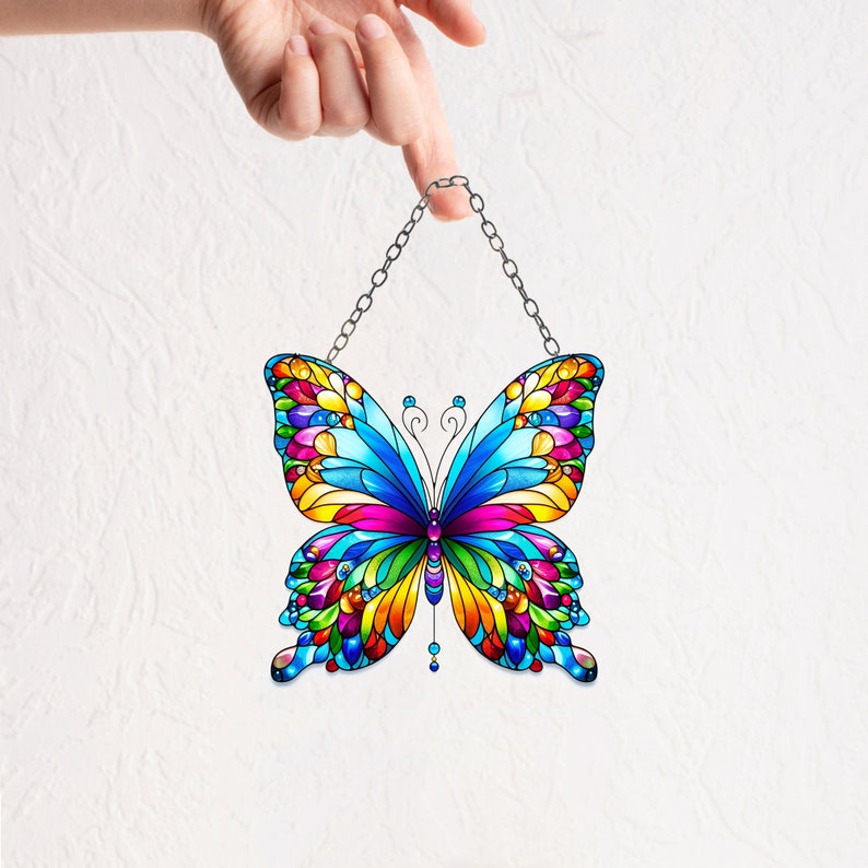 May include: A colorful stained glass butterfly suncatcher with a silver chain for hanging. The butterfly has blue wings with red, yellow, orange, green, and purple accents.