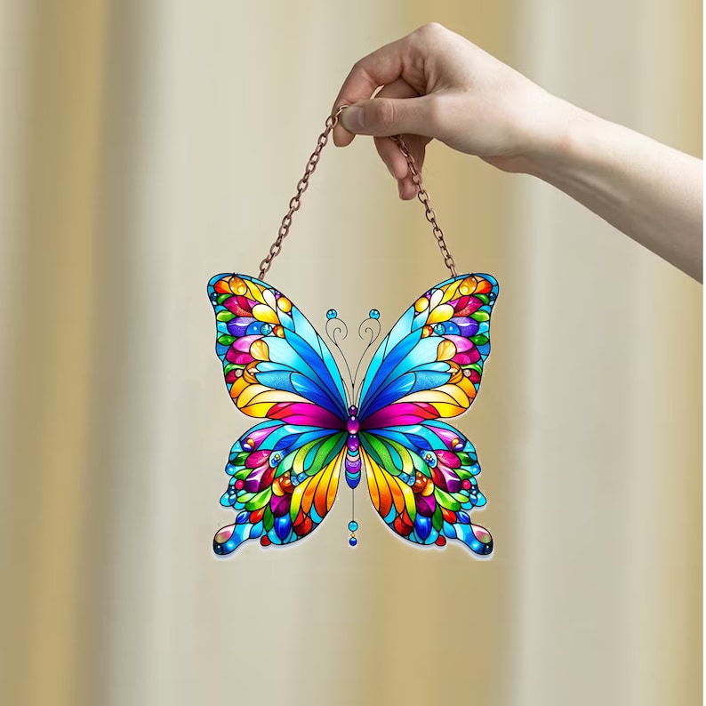 May include: A colorful stained glass butterfly suncatcher with a copper chain for hanging. The butterfly has blue, yellow, red, green, and purple wings.