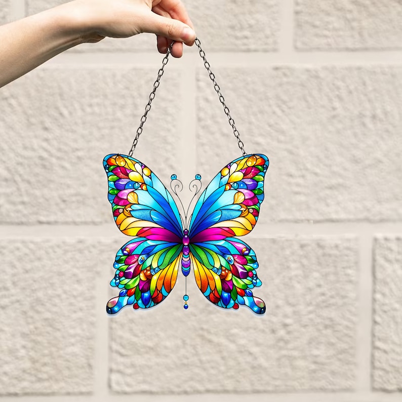 May include: A colorful stained glass butterfly suncatcher with a silver chain. The butterfly has blue, yellow, red, green, and purple wings.