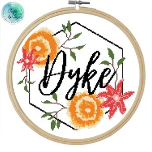 May include: Cross stitch pattern featuring the name "Dyke" in black cursive lettering surrounded by a hexagon frame with orange and red flowers.