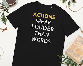 May include: Black t-shirt with white text that reads "Actions Speak Louder Than Words" in a yellow font.
