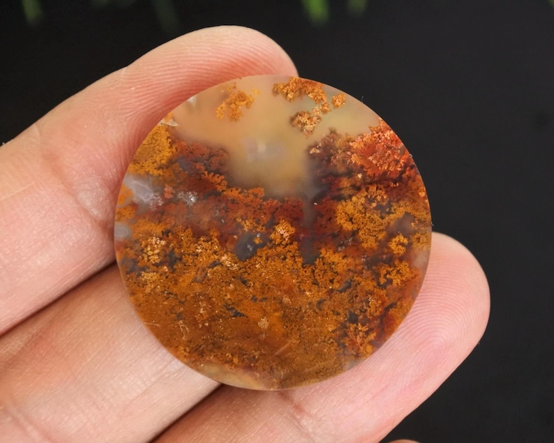 Puede incluir: Una gema redonda y pulida con un patr&oacute;n &uacute;nico. La piedra presenta una mezcla de colores c&aacute;lidos, incluyendo tonos de naranja, marr&oacute;n y crema. El dise&ntilde;o intrincado se asemeja a un paisaje o formaci&oacute;n natural.