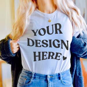 May include: A white t-shirt with the text "YOUR DESIGN HERE" in black lettering and a small heart symbol.