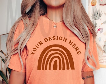 May include: A peach coloured t-shirt with a brown rainbow graphic and the text "YOUR DESIGN HERE".