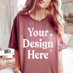 May include: A mauve colored t-shirt with the text "Your Design Here" in white. The shirt is made of a soft, comfortable material and has a relaxed fit.