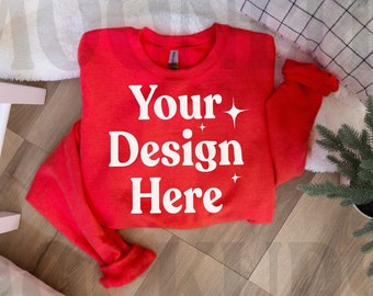 May include: Red sweatshirt with white text that says "Your Design Here" on a wood floor with a white fuzzy rug and a small potted tree.