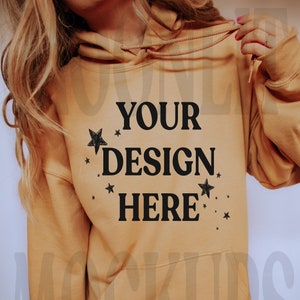 May include: A tan hoodie with a black print that says "YOUR DESIGN HERE" with small stars around the text.