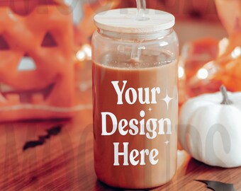 May include: A clear glass jar with a wooden lid and a straw, filled with a brown liquid. The jar has the text "Your Design Here" printed on it. The jar is sitting on a wooden table with a white pumpkin and orange pumpkins in the background.