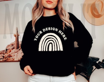 May include: A black sweatshirt with a white rainbow design and the text "Your Design Here". The model is wearing the sweatshirt with light blue jeans.