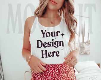 May include: White tank top with the text "Your Design Here" in black lettering. The tank top is being worn by a person with long blonde hair and a red floral skirt.