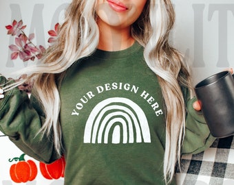 May include: A green sweatshirt with a white rainbow design and the text "YOUR DESIGN HERE".