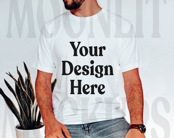 May include: A white t-shirt with the text "Your Design Here" printed in black on the front. The shirt is being worn by a person with a beard.