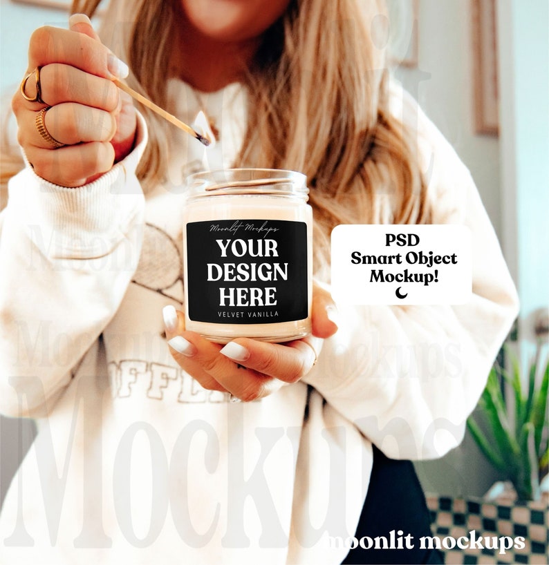 May include: A lit candle in a clear glass jar with a black label that says "YOUR DESIGN HERE" and "VELVET VANILLA". The candle is being lit with a match. The image also includes the text "PSD Smart Object Mockup!"