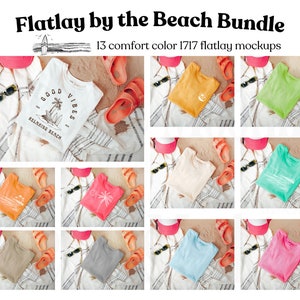 Könnte beinhalten: Ein Flatlay-Mockup-Set mit 13 verschiedenen farbigen T-Shirts, auf denen eines den Text "Good Vibes Relaxing Beach" trägt. Die Shirts liegen auf einem Strand-Hintergrund mit Sandalen, Sonnenbrillen und einem Strandtuch.