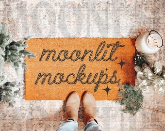 May include: A brown doormat with the text "moonlit mockups" in black rope-like lettering. The doormat is on a patterned floor with a pair of brown boots and a white lantern.